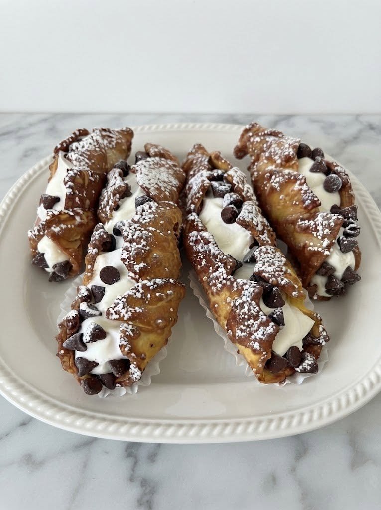 Keto Cannoli There are some desserts that feel like an occasion the moment they hit the table, and cannoli are definitely one of them. That crisp little shell, the creamy ricotta filling, the tiny bits of chocolate, and that hint of orange—it’s hard to resist. I wanted a version that would still give me that classic cannoli feeling without all the traditional sugar and flour. After a little experimenting, these Keto Cannoli became one of those desserts I love making when I want something special but still want to keep things low-carb. I especially love serving these on weekends. They look impressive, but once you get the hang of shaping the shells, they’re actually quite fun to make. And when everyone reaches for another one, you know you’ve got a winner. Traditional cannoli are known for their crisp pastry tubes and sweet ricotta-based filling, and the shells are best filled shortly before serving so they stay crunchy. 🍰 Why You’ll Love These Keto Cannoli Low-carb and sugar-free Crispy, lightly sweet almond-flour shells Creamy ricotta filling Easy to customize with chocolate, pistachios, or orange zest Perfect for holidays, parties, or weekend desserts Can be prepared ahead of time Much more satisfying than a plain keto cookie when you're craving something special 🛒 Ingredients You’ll Need For the Keto Cannoli Shells 2/3 cup almond flour 1 tablespoon psyllium husk powder 1/2 cup granulated erythritol or allulose 2 large eggs 1/4 cup melted butter or ghee 1/2 cup unsweetened coconut cream or thick coconut milk 1/2 teaspoon vanilla extract 1/2 teaspoon cinnamon Pinch of salt For the Creamy Ricotta Filling 2 cups whole-milk ricotta cheese, well drained 3/4 cup powdered erythritol or powdered monk fruit sweetener 1/2 teaspoon vanilla extract 1 tablespoon fresh orange zest 1/2 teaspoon cinnamon 1/3 cup sugar-free mini chocolate chips For Decorating Powdered keto sweetener Chopped pistachios Sugar-free chocolate chips Extra orange zest The almond-flour shell and ricotta filling combination is based on the structure used in established low-carb cannoli recipes, while the citrus, cinnamon, and chocolate keep the flavor close to a classic cannolo. 👩‍🍳 How to Make Keto Cannoli Step 1: Drain the Ricotta This step is important. Place the ricotta in a fine-mesh strainer lined with cheesecloth or a clean kitchen towel. Let it drain over a bowl for at least 1–2 hours. For the creamiest filling, you can refrigerate the ricotta overnight. You don't want watery ricotta because excess moisture can make your filling loose and your cannoli shells soggy. Step 2: Make the Cannoli Shell Batter In a bowl, whisk together: Almond flour Psyllium husk Granulated sweetener Cinnamon Salt In another bowl, whisk the eggs, melted butter, coconut cream, and vanilla. Slowly add the wet ingredients to the dry ingredients and stir until you have a thick, smooth batter. Let it sit for about 2–3 minutes so the psyllium can absorb some of the moisture. Step 3: Cook the Shells The easiest method is to use a cannoli/cone maker or pizzelle-style waffle maker. Add approximately 2 tablespoons of batter and cook until the wafer is lightly browned and firm. While the shell is still warm, carefully remove it and immediately wrap it around a cannoli tube. Press the seam together gently. You have to work fairly quickly here. Once the wafer cools, it becomes crisp and won't bend easily. A low-carb cannoli recipe using a cone maker similarly cooks individual wafers for about 5 minutes before wrapping them around cannoli tubes. No Cannoli Mold? You can make your own temporary molds using tightly rolled aluminum foil. Just make sure the foil cylinders are firm enough to hold their shape and that you can easily slide the cooled shell off. Step 4: Cool the Shells Completely Allow each shell to cool for 1–2 minutes before carefully removing the tube. Continue until you've used all of the batter. The shells should feel crisp once completely cooled. If they aren't quite crisp enough, place them on a baking sheet and warm them in a 300°F oven for several minutes, then cool again. 🥣 Step 5: Make the Ricotta Filling Add the drained ricotta to a mixing bowl. Add: Powdered keto sweetener Vanilla Orange zest Cinnamon Beat until smooth and creamy. Fold in the sugar-free chocolate chips. Taste the filling and adjust the sweetness if needed. If you prefer a very smooth filling, you can blend the ricotta briefly before adding the remaining ingredients. 🍫 Step 6: Fill the Cannoli Transfer the ricotta filling to a piping bag. Pipe the filling into one end of each cannoli shell, then turn the cannoli around and fill the other end. This gives you a beautiful, even filling from end to end. Don't fill them too far ahead of time. That's one of the biggest secrets to keeping cannoli shells crisp: fill them shortly before serving. Traditional cannoli guidance also recommends assembling them close to serving because the ricotta filling gradually softens the shell. ✨ Step 7: Add the Finishing Touches Dip each end into your favorite topping. Try: Chopped pistachios Sugar-free mini chocolate chips Finely chopped toasted almonds Orange zest Unsweetened coconut A mixture of pistachios and chocolate Finish with a very light dusting of powdered keto sweetener. And that's it. Beautiful little cannoli that look like they came from a bakery—but are made right in your kitchen. 💡 My Best Tips for Perfect Keto Cannoli 1. Drain the ricotta well This is probably the most important filling tip. Watery ricotta means watery filling. Give it plenty of time to drain. 2. Don't overfill the shells too early The filling contains moisture, and eventually that moisture will soften the crispy shell. For the best texture, keep shells and filling separate until close to serving. 3. Work quickly with warm shells The shell needs to be warm enough to bend around the mold. If it cools completely, it can crack. 4. Use powdered sweetener in the filling Powdered sweetener dissolves much more smoothly than granulated sweetener. 5. Don't skip the orange zest Even a tablespoon makes a noticeable difference. It adds that bright citrus flavor that makes the ricotta taste much more like a traditional cannoli filling. 6. Watch the chocolate chips Use a sugar-free variety and check the nutrition label because different brands can vary considerably in their carbohydrate content. 🍊 Delicious Variations Chocolate Keto Cannoli Add 1 tablespoon unsweetened cocoa powder to the shell batter. You can also add extra sugar-free chocolate chips to the filling. Pistachio Cannoli Fold 2 tablespoons finely chopped pistachios into the ricotta filling and decorate the ends with more pistachios. Lemon Cannoli Replace the orange zest with fresh lemon zest. A tiny splash of lemon juice also gives the filling a lovely brightness. Chocolate-Orange Cannoli Add orange zest and sugar-free chocolate chips to the filling, then dip the ends in melted sugar-free dark chocolate. This one feels especially decadent. Mascarpone Cannoli Replace part of the ricotta with mascarpone for an even richer filling. 🍽️ What to Serve With Keto Cannoli These are wonderful with: Espresso Unsweetened coffee Cappuccino Sugar-free hot chocolate Fresh berries A few toasted pistachios Sugar-free chocolate sauce For a dinner party, I love arranging the cannoli on a large platter and dusting everything lightly with powdered keto sweetener right before serving. They look much more complicated than they actually are. 🧊 Can You Make Keto Cannoli Ahead? Absolutely. In fact, making the components ahead makes this recipe much easier. Make the shells ahead Prepare and cool the shells completely, then store them in an airtight container at room temperature. Keep them away from moisture. Make the filling ahead The ricotta filling can be refrigerated in an airtight container for up to about 3 days. Assemble later Pipe the filling into the shells shortly before serving. This gives you the best combination of creamy filling and crisp shell. 🥶 Can You Freeze Keto Cannoli? I recommend freezing the shells and filling separately rather than freezing fully assembled cannoli. The shells can lose their crisp texture once thawed if they're exposed to the moist filling. For the best result: Freeze the cooled shells in an airtight container. Refrigerate the prepared filling. Thaw the shells at room temperature. Fill just before serving. ❓ Keto Cannoli FAQs Are cannoli keto? Traditional cannoli are generally not keto because their pastry shells contain wheat flour and sugar. This version replaces those ingredients with almond flour and keto-friendly sweeteners, making it much more suitable for a low-carb or ketogenic eating pattern. Why are my cannoli shells soft? Usually, moisture is the problem. Make sure the shells are fully crisp before filling and don't assemble them too early. Can I use mascarpone instead of ricotta? Yes. Mascarpone makes the filling richer and creamier. You can replace some or all of the ricotta depending on your preference. Can I use cottage cheese? You can, but it won't have quite the same classic cannoli flavor. If using cottage cheese, blend it until completely smooth and drain it well first. Can I make these without psyllium husk? Psyllium helps provide structure in the almond-flour shell. You can experiment with other keto-friendly binders, but the texture may change. What sweetener is best? Powdered erythritol, monk fruit blends, or allulose can work. For the filling, powdered sweetener is preferable because it blends more smoothly. Can I use regular chocolate chips? You can, but regular chocolate chips will add sugar and carbohydrates. For a keto version, use sugar-free chocolate chips and check the label. How long do filled cannoli last? They're best eaten soon after filling. The longer they sit, the softer the shell becomes. 📝 Keto Cannoli Recipe at a Glance Prep Time: 30 minutes Cook Time: 15–20 minutes Cooling/Assembly: 20–30 minutes Total Time: About 1 hour 10 minutes Yield: About 12 cannoli Ingredients Shells 2/3 cup almond flour 1 tbsp psyllium husk powder 1/2 cup granulated keto sweetener 2 eggs 1/4 cup melted butter 1/2 cup unsweetened coconut cream 1/2 tsp vanilla 1/2 tsp cinnamon Pinch salt Filling 2 cups drained whole-milk ricotta 3/4 cup powdered keto sweetener 1/2 tsp vanilla 1 tbsp orange zest 1/2 tsp cinnamon 1/3 cup sugar-free mini chocolate chips Instructions Drain ricotta thoroughly. Mix almond flour, psyllium, sweetener, cinnamon, and salt. Whisk eggs, butter, coconut cream, and vanilla. Combine wet and dry ingredients. Cook approximately 2 tablespoons of batter at a time in a cone/cannoli maker until lightly browned. Wrap each warm wafer around a cannoli tube. Cool completely and remove the molds. Beat drained ricotta with sweetener, vanilla, orange zest, and cinnamon. Fold in sugar-free chocolate chips. Pipe filling into both ends of each shell. Decorate with pistachios, chocolate chips, or orange zest. Dust lightly with powdered keto sweetener and serve immediately. ❤️ A Little Final Note These Keto Cannoli are the kind of dessert that make a low-carb lifestyle feel a little less restrictive. You still get the crunchy shell, the creamy ricotta, the little chocolate bites, and that beautiful citrus-cinnamon flavor. They're not meant to replace the traditional Sicilian pastry exactly—they're a keto-friendly interpretation that lets you enjoy the spirit of cannoli while keeping the ingredients low in sugar. And honestly, there's something really satisfying about bringing a plate of homemade cannoli to the table and watching everyone grab one before you've even had a chance to sit down. Crispy shell. Creamy center. Chocolate on the edges. That's a dessert worth making. ❤️