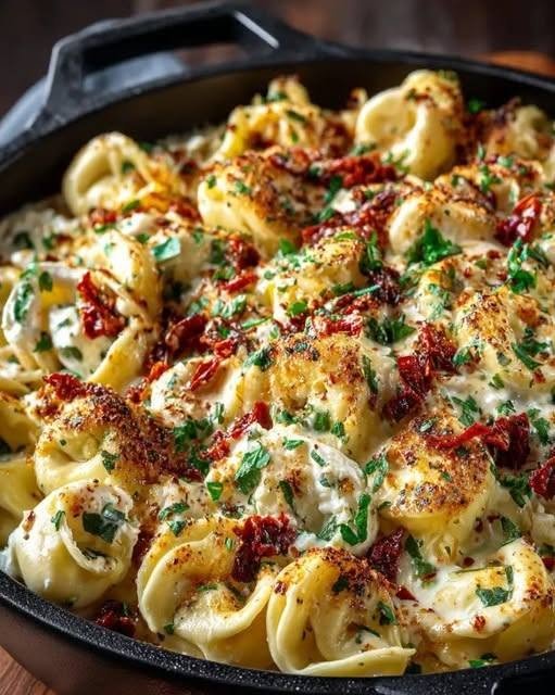 Baked Sundried Tomato Tortellini There are some dinners that feel like a warm hug the moment they come out of the oven, and this Baked Sundried Tomato Tortellini is definitely one of them. I made this on a weekend when I wanted something comforting without spending the entire afternoon in the kitchen. I had a package of cheese tortellini waiting in the refrigerator and a jar of sun-dried tomatoes in the pantry, and suddenly dinner started coming together. As the sauce simmered, the kitchen filled with the smell of garlic, tomatoes, and Italian herbs. Then came the cheese. Once that bubbling, golden layer of mozzarella and Parmesan appeared on top, everyone seemed to find a reason to wander into the kitchen. That was the moment I knew this recipe was going to become a regular. It's creamy, saucy, cheesy, and packed with the concentrated sweet-tangy flavor of sun-dried tomatoes. Best of all, it feels like a special Italian-inspired dinner while being simple enough for a busy weeknight. Why You'll Love This Baked Tortellini Incredibly comforting: Tender cheese tortellini baked in a rich tomato sauce. Packed with flavor: Sun-dried tomatoes add a concentrated savory-sweet tomato flavor. Extra cheesy: Mozzarella and Parmesan create a bubbly, golden topping. Easy enough for weeknights: The sauce comes together quickly. Family-friendly: It's cheesy, familiar, and easy to make mild. Great for leftovers: It reheats beautifully for lunch the next day. Easy to customize: Add spinach, mushrooms, chicken, sausage, or extra herbs. Ingredients For the Sauce 1 tablespoon olive oil 1 small yellow onion, finely chopped 3 cloves garlic, minced 1 can (28 ounces) crushed tomatoes 1/2 cup chicken or vegetable broth 1/2 cup oil-packed sun-dried tomatoes, drained and thinly sliced 1 teaspoon dried oregano 1/2 teaspoon dried basil 1/4 teaspoon red pepper flakes, optional 1/2 teaspoon salt 1/4 teaspoon freshly ground black pepper For the Tortellini 1 package (about 19 ounces) fresh cheese tortellini 2 cups shredded mozzarella, divided 1/2 cup freshly grated Parmesan For Garnishing 1/4 cup fresh basil, chopped Extra Parmesan, optional A drizzle of olive oil, optional Fresh cheese tortellini works particularly well here because it can cook directly in the simmering sauce before the whole dish goes into the oven. How to Make Baked Sundried Tomato Tortellini 1. Preheat the Oven Preheat your oven to 375°F (190°C). Lightly grease a 9×13-inch baking dish with olive oil or cooking spray. If you have an oven-safe skillet large enough to hold everything, you can also prepare the sauce there and then transfer the mixture to the baking dish. 2. Sauté the Onion Heat the olive oil in a large skillet over medium heat. Add the chopped onion and cook for about 5–7 minutes, stirring occasionally, until softened and translucent. Don't rush this step. Letting the onion soften slowly gives the sauce a much better flavor. 3. Add the Garlic Stir in the minced garlic and cook for about 30–60 seconds, just until fragrant. Be careful not to let it brown too much. There's something about garlic hitting warm olive oil that immediately makes the kitchen smell like dinner is going to be good. 4. Build the Tomato Sauce Add the crushed tomatoes and broth. Then stir in: Sun-dried tomatoes Oregano Basil Red pepper flakes Salt Black pepper Bring the mixture to a gentle simmer. Reduce the heat and let it cook for about 10 minutes, stirring occasionally. This short simmer gives the sun-dried tomatoes time to mingle with the tomato sauce and herbs. 5. Add the Tortellini Gently stir the fresh tortellini directly into the simmering sauce. Make sure each piece is coated. Let it cook gently for a few minutes according to the texture of your particular fresh tortellini. You don't want to fully overcook it at this stage because it will continue cooking in the oven. Remove the skillet from the heat. 6. Add Some Cheese to the Sauce Stir 1 cup of the mozzarella into the tortellini mixture. This gives the inside of the bake a lovely cheesy texture rather than putting all the cheese only on top. 7. Transfer to the Baking Dish Pour the tortellini mixture into your prepared baking dish. Spread it out evenly. Sprinkle the remaining mozzarella over the top, followed by the Parmesan. Try to cover the surface fairly evenly so you get those beautiful golden, cheesy bites all the way across the dish. 8. Bake Place the dish in the oven and bake for 20–25 minutes. You’re looking for: Bubbling sauce around the edges Melted mozzarella Lightly golden cheese on top Tortellini that is tender but not mushy If you want an extra-deep golden top, switch the oven to broil for about 1 minute at the end. Watch it closely—cheese can go from golden to burnt very quickly. 9. Let It Rest This little step makes a bigger difference than you might expect. Remove the tortellini from the oven and let it rest for 5–10 minutes before serving. The sauce thickens slightly during this time, making it much easier to scoop and serve. Finish with fresh basil and a little extra Parmesan. Then dig in. The Secret to Really Good Sun-Dried Tomato Tortellini The sun-dried tomatoes are the star here. I recommend using oil-packed sun-dried tomatoes rather than dry-packed ones. They're tender, intensely flavorful, and easy to slice into the sauce. And if your sun-dried tomatoes are packed in good olive oil, don't throw that oil away without thinking twice. A small drizzle can add wonderful flavor to other pasta sauces, salad dressings, roasted vegetables, or marinades. Should I Use Fresh or Frozen Tortellini? I prefer fresh cheese tortellini for this recipe because it cooks quickly and has a tender texture. Frozen tortellini can work too. You may need to adjust the cooking time slightly to make sure the pasta cooks completely. Don't simply assume every tortellini package will behave exactly the same way—check the package directions and use the texture of the pasta as your guide. Easy Add-Ins This recipe is delicious exactly as written, but it's also a wonderful starting point. Add Spinach Stir 2–3 handfuls of fresh baby spinach into the hot sauce before adding the tortellini. The spinach wilts quickly and pairs beautifully with sun-dried tomatoes. Add Mushrooms Sauté sliced mushrooms with the onions until golden before adding the garlic. Add Chicken Stir in cooked shredded or chopped chicken for a heartier dinner. Rotisserie chicken makes this especially easy. Add Italian Sausage Brown Italian sausage separately, drain any excess fat, and stir it into the tortellini mixture. Use mild sausage for a family-friendly version or spicy sausage for extra heat. Add Artichokes Chopped marinated artichoke hearts make a wonderful Mediterranean-style addition. Make It Spicy Increase the red pepper flakes or add a pinch of crushed chili flakes. What to Serve With Baked Sundried Tomato Tortellini Because this dish is rich and cheesy, I love serving it with something fresh on the side. Try: Simple green salad Arugula salad with lemon Garlic bread Roasted zucchini Steamed broccoli Green beans Roasted asparagus Italian-style chopped salad A crisp green salad with a simple lemony dressing is probably my favorite pairing. The freshness balances the rich cheese and tomato sauce beautifully. Make-Ahead Instructions This is a great recipe to prepare ahead of time. Assemble the tortellini bake, cover it tightly, and refrigerate it until you're ready to bake. Because the dish starts cold, you'll need to allow a little extra baking time. I recommend taking it out of the refrigerator while the oven preheats rather than putting a very cold baking dish straight into a hot oven, particularly if your dish is made of glass. How to Store Leftovers Let leftovers cool and transfer them to an airtight container. Refrigerate for up to 4 days. When you're ready to reheat, microwave individual portions until hot, or cover the baking dish with foil and warm it in a 350°F oven for about 15–20 minutes. The sauce may thicken slightly after refrigeration, so a small splash of broth or water can help loosen it during reheating. Can You Freeze Baked Tortellini? Yes. Allow the dish to cool completely, then portion it into freezer-safe containers. Freeze for up to about 3 months. For best results, thaw overnight in the refrigerator before reheating. My Best Tips Don't drown the tortellini You want plenty of sauce, but the final dish shouldn't be soupy. The sauce will loosen slightly as the tortellini cooks and then thicken as the casserole rests. Don't overcook the tortellini before baking Remember that the tortellini gets additional cooking time in the oven. Use freshly grated Parmesan It melts more smoothly and gives the topping a wonderful savory flavor. Let the bake rest Those 5–10 minutes after baking really help the sauce settle. Add fresh basil at the end Dried basil gives the sauce a nice background flavor, but fresh basil at the end adds brightness that makes the whole dish taste fresher. Frequently Asked Questions Can I use frozen tortellini? Yes. Frozen tortellini can be used, although you may need to adjust the cooking time. Follow the package directions and make sure the tortellini is tender before serving. Can I use ravioli instead? Absolutely. Cheese ravioli makes a great substitute. Just keep in mind that the size and cooking time may be different. Can I make this vegetarian? Yes. Use vegetable broth instead of chicken broth. The rest of the basic recipe is vegetarian-friendly. Can I make it gluten-free? Yes. Use gluten-free tortellini and verify that your broth, sun-dried tomatoes, and other packaged ingredients are gluten-free. How do I make it creamier? For a creamier version, stir 1/2 cup heavy cream or 4 ounces of softened cream cheese into the tomato sauce before adding the tortellini. You can also add a little extra Parmesan. Can I add pesto? Definitely. A spoonful of basil pesto stirred into the finished sauce adds even more basil and garlic flavor. Can I make this spicy? Yes. Add extra red pepper flakes, or use hot Italian sausage if you're adding sausage. Why should I let it rest before serving? The short resting period allows the sauce to thicken slightly and makes the tortellini easier to serve without everything sliding around the plate. Recipe at a Glance Prep Time: 15 minutes Cook Time: 35–45 minutes Resting Time: 5–10 minutes Total Time: About 1 hour Servings: 4–6 Final Thoughts This Baked Sundried Tomato Tortellini is exactly the kind of dinner I love having in my recipe rotation. It isn't fussy. It doesn't require a long list of complicated ingredients. And yet, when you pull that bubbling dish of cheesy tortellini from the oven, it feels like you've made something really special. The sun-dried tomatoes give the tomato sauce incredible depth, the garlic and herbs keep everything wonderfully savory, and that golden mozzarella-Parmesan topping makes every serving irresistible. It's the kind of meal where everyone says they're only going to have a little—and then someone goes back for another scoop. And honestly, I can't blame them. Creamy tomato sauce, tender cheese tortellini, intensely flavorful sun-dried tomatoes, and a bubbling blanket of cheese—this is comfort food worth gathering around the table for.
