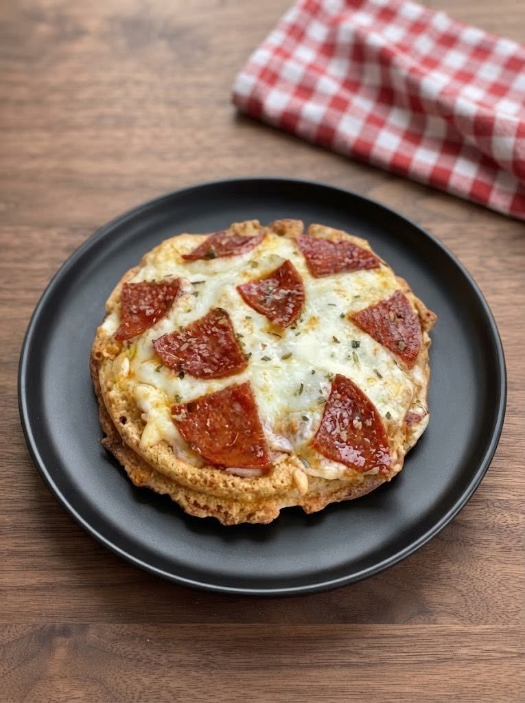 🍕 Keto Pizza Chaffle There are nights when you want pizza so badly that salad just isn't going to cut it. You want the melted cheese. You want the crispy edges. You want the pepperoni getting a little browned and bubbly on top. And, honestly, you want something you can pick up with your hands and eat without feeling like you're missing out. That's exactly how this Keto Pizza Chaffle came to be one of my favorite quick meals. I first made these on a weekend when everyone was in the mood for pizza, but I didn't want to spend an hour making a traditional low-carb crust. I had eggs, mozzarella, a little almond flour, and some pepperoni in the refrigerator, so I decided to experiment. The first bite completely sold me. The chaffle was crisp around the edges, cheesy in the middle, and sturdy enough to hold the pizza toppings without falling apart. Once I added a little pizza sauce, more mozzarella, and pepperoni, it honestly felt like I had made tiny personal pizzas. My family loved them. And now these are one of those recipes I keep coming back to whenever I want something quick, cheesy, comforting, and keto-friendly. The best part? You don't need yeast. You don't need to wait for dough to rise. You don't need a rolling pin. Just mix, waffle, top, and bake. And about 15 minutes later, you're holding a crispy little pizza in your hand. 🍕 ❤️ Why You'll Love This Keto Pizza Chaffle There is a lot to love about these little pizzas. Quick enough for a busy weeknight Perfect for lunch, dinner, or a snack Crispy around the edges and cheesy inside Naturally low in carbohydrates when keto-friendly ingredients are used No yeast or traditional flour Easy to customize with your favorite toppings Great for portion control Family-friendly and kid-approved Can be made ahead Perfect for satisfying pizza cravings A traditional chaffle is essentially a cheese-and-egg waffle, and keto pizza versions build on that idea with pizza flavors and toppings. Some versions are made with only egg and mozzarella, while others add almond flour or cream cheese for a different texture. 🛒 Ingredients For the Chaffle 2 large eggs 1 cup shredded mozzarella cheese ¼ cup finely ground almond flour ½ teaspoon baking powder ½ teaspoon Italian seasoning ¼ teaspoon garlic powder ¼ teaspoon salt For the Pizza Topping 2 tablespoons low-carb pizza sauce ½ cup shredded mozzarella cheese 12–16 slices pepperoni ¼ teaspoon Italian seasoning Fresh basil, optional Red pepper flakes, optional For the Waffle Maker Nonstick cooking spray or a little olive oil The almond flour helps give the chaffle a more substantial texture, while mozzarella provides the cheesy structure that makes a chaffle work. 👩‍🍳 How to Make Keto Pizza Chaffles 1. Preheat Your Waffle Maker Start by heating your waffle maker according to its instructions. A mini waffle maker works especially well because it creates individual pizza-sized chaffles. Lightly spray the plates with nonstick spray. You don't need a lot. Just enough to make releasing the chaffle easy. 🧀 2. Make the Chaffle Batter In a medium bowl, whisk the eggs until they're well combined. Add: Mozzarella Almond flour Baking powder Italian seasoning Garlic powder Salt Stir everything together until evenly mixed. The mixture will be fairly thick and cheesy. That's exactly what you want. 🧇 3. Cook the Chaffles Spoon the mixture into the center of the preheated waffle maker. Don't overfill it. Close the lid and cook for approximately 3–5 minutes, or until the chaffle is golden brown and the edges look crisp. Try not to open the waffle maker too early. I know it's tempting. But letting the chaffle cook undisturbed helps it develop that crispy exterior and makes it easier to remove in one piece. 🍕 4. Add the Pizza Toppings Carefully remove the cooked chaffle and place it on a baking sheet or air-fryer-safe tray. Spread about 1 tablespoon of low-carb pizza sauce over the top. Don't use too much sauce. A thin layer gives you plenty of tomato flavor without making the chaffle soggy. Sprinkle with mozzarella. Add pepperoni. Finish with a little Italian seasoning. At this point, it already looks like a tiny pizza, and this is usually the moment when everyone starts wandering into the kitchen asking when dinner is ready. 🔥 5. Melt the Cheese Place the topped chaffles in a preheated 350°F (175°C) oven. Bake for approximately 5–8 minutes, or until the cheese is melted and bubbling. For an even crispier finish, you can use an air fryer at 350°F (175°C) for approximately 3–5 minutes. Keep an eye on them because small chaffles can brown quickly. Pizza-chaffle recipes commonly finish the cooked chaffle with sauce, cheese, and toppings and then return it briefly to the oven or air fryer until the topping cheese melts. 🌿 6. Finish and Serve Remove the pizza chaffles from the oven. Let them cool for a minute or two. Add fresh basil if you like. For a little heat, sprinkle over some red pepper flakes. Then serve immediately. That first bite is the best. Crispy edges. Cheesy center. Warm tomato sauce. Pepperoni. And all those familiar pizza flavors packed into a tiny chaffle. ⭐ My Best Tips for Crispy Keto Pizza Chaffles Don't overfill the waffle maker This is probably the easiest mistake to make. The batter expands as it cooks, so start with less than you think you need. You can always add more. Let the waffle maker get hot A properly preheated waffle maker helps the outside crisp instead of leaving you with a soft, eggy texture. Don't open it too early Give the chaffle time to set. If you lift the lid too soon, it can separate or stick. Use finely shredded cheese Smaller shreds incorporate more evenly into the batter. Don't overload the sauce Too much sauce can make the chaffle soft. Remember, we're making pizza—not soup. 😂 Let it cool briefly The chaffle becomes a little firmer as it sits for a minute. This makes it easier to pick up. 🍕 Favorite Toppings for Keto Pizza Chaffles This is where the fun really starts. You can make every chaffle different. Pepperoni The classic. Add plenty of pepperoni and let the edges get slightly crispy. Sausage Cooked crumbled Italian sausage makes these extra hearty. Bacon Because bacon makes almost everything better. Mushrooms Thinly sliced mushrooms add a wonderful savory flavor. Bell Peppers Use thin strips of green, red, or yellow pepper. Olives Black or green olives work beautifully with the salty cheese. Jalapeños Perfect if you like spicy pizza. Chicken Use cooked diced chicken for a more filling meal. Extra Cheese Mozzarella, cheddar, Parmesan, or a little provolone can all work. 🧄 Easy Flavor Variations Garlic Parmesan Pizza Chaffle Add extra garlic powder to the chaffle batter and finish with Parmesan and parsley. Buffalo Chicken Chaffle Top with cooked chicken tossed in buffalo sauce, mozzarella, and a drizzle of ranch after baking. Meat Lovers Use pepperoni, cooked sausage, bacon, and extra mozzarella. This one disappears fast. Supreme Pizza Chaffle Add pepperoni, sausage, mushrooms, olives, and peppers. Margherita Chaffle Use pizza sauce, fresh mozzarella, basil, and a little Parmesan. Jalapeño Popper Pizza Top with mozzarella, diced jalapeños, and small dots of cream cheese. BBQ Chicken Replace pizza sauce with a small amount of sugar-free BBQ sauce and add chicken, mozzarella, and red onion. 🥩 Make It More Filling If you're serving these as a complete meal rather than a snack, add a protein-rich topping. Try: Italian sausage Ground beef Pepperoni Bacon Grilled chicken Shredded chicken Ham Turkey pepperoni You can also serve two or three smaller chaffles with a simple salad for a satisfying dinner. 🥗 What to Serve With Keto Pizza Chaffles These are delicious on their own, but if you're making dinner, try serving them with: Caesar salad Simple green salad Garlic butter broccoli Roasted cauliflower Zucchini fries Cucumber salad Steamed green beans Antipasto salad Avocado salad For a casual family dinner, I love putting all the toppings on the table and letting everyone build their own. It's easy, fun, and nobody complains about getting the "wrong" pizza. 🧊 Can You Make Pizza Chaffles Ahead of Time? Absolutely. Make the chaffles according to the recipe, then allow them to cool completely. Store the plain chaffles in an airtight container in the refrigerator. When you're ready to eat, add your pizza sauce, cheese, and toppings and reheat them in the oven or air fryer. I actually prefer making the chaffle bases ahead of time because it turns this recipe into an almost instant meal. ❄️ Can You Freeze Keto Pizza Chaffles? Yes. For best results, freeze the plain cooked chaffles before adding the pizza toppings. Place parchment paper between them so they don't stick together. Store in a freezer-safe bag or container for up to about 2 months for best quality. To reheat, place them directly into an air fryer or oven until hot and crisp. Then add your sauce and toppings and cook until the cheese melts. 🔥 Air Fryer Instructions If you love crispy food, the air fryer is your friend. Cook the chaffle base in the waffle maker first. Then add sauce, cheese, and toppings. Place it in a preheated air fryer at 350°F (175°C) for approximately 3–5 minutes. Watch carefully during the last minute. The cheese can go from perfectly bubbly to overly browned surprisingly quickly. ❓ Frequently Asked Questions What is a chaffle? A chaffle is a keto-style waffle made primarily with cheese and egg. The name combines "cheese" and "waffle." Different versions may add ingredients such as almond flour, cream cheese, or seasonings. Are pizza chaffles keto? They can be. The chaffle itself is generally low in carbohydrates, but pizza sauce and toppings can add carbs. For a strict keto approach, choose a low-carb or no-sugar-added pizza sauce and check the labels on processed toppings. Can I make these without almond flour? Yes. You can make a simpler egg-and-cheese version using mozzarella and egg. The texture will be different and may be softer, but it can still make a delicious pizza base. Some pizza-chaffle recipes use only egg and mozzarella. Can I use coconut flour instead? Yes, but coconut flour absorbs much more liquid than almond flour. Use a small amount rather than substituting it cup-for-cup. Why is my chaffle soggy? There are a few possible reasons. You may have added too much sauce, undercooked the chaffle, overcrowded the waffle maker, or used toppings with a lot of moisture. Cook the chaffle until golden and crisp before adding toppings. Why does my chaffle taste too eggy? Make sure it's cooked long enough to develop a golden exterior. Seasonings such as garlic powder and Italian seasoning also help give the chaffle a more savory, pizza-like flavor. Can I use cheddar instead of mozzarella? Absolutely. Cheddar will give you a stronger flavor and a slightly different texture. For the closest pizza flavor, I prefer mozzarella, but a mozzarella-cheddar blend is delicious. Can I make these without pepperoni? Of course. Try sausage, bacon, chicken, mushrooms, olives, peppers, or simply extra cheese. Can I make them vegetarian? Yes. Skip the meat and load them up with mushrooms, peppers, olives, spinach, tomatoes, or other keto-friendly vegetables. Can I make a larger chaffle? Yes, but you'll need to adjust the amount of batter and cooking time depending on the size of your waffle maker. A mini waffle maker creates individual portions and makes it easier to control the amount of batter. 🍽️ Recipe at a Glance Prep Time: 5 minutes Cook Time: 10–15 minutes Total Time: About 15–20 minutes Servings: 2–4, depending on waffle maker size Category: Breakfast / Lunch / Dinner / Snack Cuisine: Keto / Low-Carb Cooking Method: Waffle Maker + Oven or Air Fryer ❤️ The Little Pizza That Saves Pizza Night I think that's what I love most about these Keto Pizza Chaffles. They don't try to be something complicated. They're just a clever little answer to a very real craving. Sometimes you want pizza on a Tuesday night. Sometimes you're tired. Sometimes everyone else is eating pizza and you want to join in without making an entirely separate dinner. And sometimes you simply want something hot, cheesy, crispy, and comforting. That's when I make these. I love how quickly they come together, and I especially love how easy they are to customize. One can be loaded with pepperoni, another with sausage, and another can be covered in vegetables and extra cheese. Everyone gets exactly what they want. And when that melted cheese starts bubbling and the pepperoni edges get crispy? That's when I know dinner is going to be a hit. So if you're craving pizza but don't want to make a traditional crust, grab your waffle maker. Whisk the eggs. Add the cheese. Get those chaffles nice and golden. Then pile on your favorite toppings. Because sometimes the best pizza isn't a giant slice. Sometimes it's a little crispy waffle covered in cheese and pepperoni. And honestly, I'm completely okay with that. 🍕