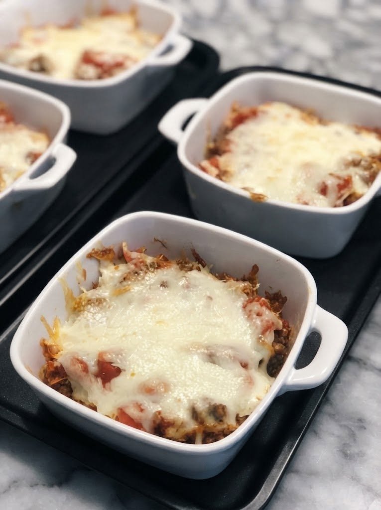 Keto Lasagna in a Bowl There are nights when you want lasagna so badly that nothing else will quite do. You want the rich tomato sauce. You want the seasoned beef. You want that creamy ricotta layer. And most importantly, you want a ridiculous amount of melted mozzarella on top. But sometimes the thought of making an entire pan of lasagna is just too much. That's where this Keto Lasagna in a Bowl comes to the rescue. I started making this on evenings when I was craving classic lasagna but wanted something quicker and without the traditional noodles. Instead of spending all that time layering a casserole, I took all the best parts of lasagna and put them together in individual bowls. And honestly, I may like this version even more. Every spoonful has savory beef, rich marinara, creamy ricotta, Parmesan, and gooey mozzarella. It's warm, cheesy, saucy, and incredibly comforting. I made it for my family one weekend, and everyone immediately started customizing their bowls. One person wanted extra mozzarella, someone added more Parmesan, and another went straight for the red pepper flakes. By the time dinner was over, every bowl was completely empty. That's when I knew this was going into the regular dinner rotation. Because sometimes you don't need to reinvent lasagna. You just need to make it easier. ❤️ Why You'll Love This Keto Lasagna in a Bowl All the classic flavors of lasagna without traditional pasta Ready in about 30 minutes No complicated layering Perfectly portioned into individual bowls Rich, creamy, cheesy, and satisfying Easy to customize Great for busy weeknights Excellent for meal prep Easy to make spicy or mild Perfect for those serious lasagna cravings And the best part? You can make one bowl or several. So whether you're cooking for yourself or feeding the whole family, this recipe is incredibly flexible. 🛒 Ingredients For the Meat Sauce 1 pound ground beef 1 tablespoon olive oil ½ small yellow onion, finely diced 3 cloves garlic, minced 1½ cups low-carb marinara sauce 1 teaspoon Italian seasoning ½ teaspoon garlic powder ½ teaspoon onion powder ½ teaspoon salt ¼ teaspoon black pepper ¼ teaspoon red pepper flakes, optional For the Ricotta Layer 1 cup whole-milk ricotta cheese ½ cup freshly grated Parmesan cheese ½ teaspoon Italian seasoning ¼ teaspoon garlic powder ¼ teaspoon salt ¼ teaspoon black pepper For the Topping 1 cup shredded mozzarella cheese 2 tablespoons Parmesan cheese Fresh parsley, for garnish Optional red pepper flakes Optional Vegetable Base You can spoon the lasagna mixture over: Sautéed zucchini noodles Steamed broccoli Sautéed spinach Roasted cauliflower Or skip the vegetables completely and enjoy the lasagna filling on its own. 👩🍳 How to Make Keto Lasagna in a Bowl 1. Brown the Beef Heat the olive oil in a large skillet over medium-high heat. Add the ground beef and break it apart with a wooden spoon. Cook for approximately 7–10 minutes, stirring occasionally, until the beef is browned and cooked through. If there is a lot of excess grease, carefully drain it. A little fat adds flavor, but you don't want the finished bowl swimming in grease. 🧅 2. Add the Onion and Garlic Add the diced onion to the skillet. Cook for about 3–4 minutes, until the onion begins to soften. Add the minced garlic and cook for another 30–60 seconds. At this point, your kitchen should already smell like Italian comfort food. 🍅 3. Add the Marinara Pour the low-carb marinara sauce into the skillet. Add: Italian seasoning Garlic powder Onion powder Salt Black pepper Red pepper flakes, if using Stir everything together. Reduce the heat to medium-low and let the sauce simmer for about 5–8 minutes. This gives the beef time to absorb all those tomato and herb flavors. Taste and adjust the seasoning if needed. 🧀 4. Make the Ricotta Mixture While the meat sauce simmers, prepare the creamy cheese layer. In a bowl, combine: Ricotta Parmesan Italian seasoning Garlic powder Salt Black pepper Stir until smooth and creamy. This simple mixture is one of my favorite parts of the whole recipe. It's rich without needing a complicated sauce. 🥣 5. Prepare Your Bowls Use four microwave-safe or oven-safe bowls. If you're using a vegetable base, place a layer of sautéed zucchini, broccoli, spinach, or cauliflower in the bottom. You don't need much. Just enough to give the bowl some extra texture. If you're skipping vegetables, simply start with the meat sauce. 🍝 6. Build the Lasagna Bowls Spoon some of the hot meat sauce into each bowl. Add a generous spoonful of the ricotta mixture. Then add another layer of meat sauce. Top each bowl with shredded mozzarella. Finish with a little Parmesan. Don't worry about making the layers perfect. This isn't traditional lasagna. It's supposed to be easy. 🔥 7. Melt the Cheese There are two easy ways to finish the bowls. Microwave Method Place one bowl in the microwave. Heat in 30–60 second intervals until the cheese is melted and bubbling. Repeat with the remaining bowls. Oven Method Place the oven-safe bowls on a baking sheet. Bake at 375°F (190°C) for about 10–15 minutes, until hot and bubbly. For a golden cheese topping, switch to broil for 1–2 minutes at the end. Keep a close eye on it. That mozzarella can brown quickly. 🌿 8. Finish and Serve Remove the bowls carefully—they will be hot. Sprinkle with fresh parsley. Add extra Parmesan if you love cheese as much as I do. A few red pepper flakes are also fantastic if you want some heat. Then let the bowls sit for about 2–3 minutes before digging in. That first spoonful is everything. You get creamy ricotta, rich meat sauce, and stretchy mozzarella all at once. 🥒 Optional: Add a Vegetable Base If you want more vegetables in your meal, this is an easy place to add them. Zucchini Noodles Sauté zucchini noodles for just a few minutes and place them underneath the meat sauce. Broccoli Steam broccoli until tender-crisp and use it as the base. Spinach Quickly sauté fresh spinach with garlic and butter. Cauliflower Roast or steam cauliflower and spoon the lasagna mixture over the top. The vegetables aren't necessary, but they're an easy way to turn the bowl into a more substantial meal. ⭐ Tips for the Best Keto Lasagna Bowl Choose a low-carb marinara Many jarred sauces contain added sugar, so check the label when you're keeping the meal strictly keto. Don't make the ricotta mixture too wet Whole-milk ricotta works beautifully, but if yours seems particularly watery, drain off excess liquid first. Use freshly grated Parmesan It melts better and gives the ricotta mixture a richer flavor. Don't overcook the beef Once it's browned and cooked through, move on. The meat will continue simmering in the sauce. Don't skimp on mozzarella That bubbling cheese on top is what makes this feel like lasagna. Let it cool briefly Give the bowl a couple of minutes before eating. The cheese and sauce will be extremely hot. 🥓 Delicious Variations Keto Meat Lovers Lasagna Bowl Add cooked Italian sausage and crispy bacon to the ground beef. This one is seriously indulgent. Spicy Lasagna Bowl Use hot Italian sausage, extra red pepper flakes, and a pinch of cayenne. Chicken Alfredo Lasagna Bowl Replace the beef and marinara with shredded chicken and a low-carb Alfredo sauce. Use ricotta, Parmesan, and mozzarella just as you would here. Mushroom Lasagna Bowl Sauté sliced mushrooms with the onions before adding the beef. The earthy mushrooms are wonderful with tomato sauce and ricotta. Spinach Ricotta Lasagna Bowl Mix chopped sautéed spinach directly into the ricotta filling. It's creamy, savory, and delicious. Pepperoni Pizza Lasagna Bowl Add chopped pepperoni to the meat sauce and replace some of the Italian seasoning with pizza seasoning. Top with extra mozzarella. Three-Cheese Lasagna Bowl Use ricotta, mozzarella, and Parmesan. For an even richer version, add a little provolone. 🌶️ Topping Ideas Once the cheese has melted, you can take your bowl in several directions. Try: Fresh basil Fresh parsley Parmesan Red pepper flakes Chopped green onions Sautéed mushrooms Crispy bacon Chopped pepperoni Diced jalapeños Extra mozzarella A drizzle of olive oil My favorite combination is fresh basil, Parmesan, and a pinch of red pepper flakes. 🥗 What to Serve With Keto Lasagna in a Bowl Because this is such a rich and satisfying meal, I like serving something fresh alongside it. Try: Simple green salad Caesar salad Arugula salad Roasted broccoli Garlic green beans Sautéed zucchini Cucumber salad Roasted asparagus You can also serve a small portion of keto garlic bread alongside it if you want the full Italian comfort-food experience. 🕐 Can I Make These Ahead? Absolutely. Prepare the beef sauce and ricotta mixture ahead of time. Store them separately in airtight containers in the refrigerator. When you're ready to eat, assemble your bowls, add mozzarella and Parmesan, and heat until bubbling. This makes the recipe particularly useful for meal prep. You can even portion the ingredients into individual containers so dinner is ready to assemble throughout the week. 🧊 Storage Store leftover meat sauce and ricotta mixture in separate airtight containers in the refrigerator for up to 3–4 days. If you've already assembled the bowls, cover them tightly and refrigerate. Reheat until completely hot. For the best cheese texture, add a fresh sprinkle of mozzarella before reheating. ❄️ Can You Freeze Keto Lasagna Bowls? Yes. The meat sauce freezes especially well. For the best texture, freeze the meat sauce separately and prepare the ricotta mixture fresh. Store the cooked meat sauce in a freezer-safe container for up to 2–3 months. Thaw overnight in the refrigerator, reheat, then assemble the bowl with fresh ricotta and mozzarella. ❓ Frequently Asked Questions Is lasagna in a bowl keto? It can be. This version skips traditional pasta and uses ground beef, ricotta, Parmesan, mozzarella, and a low-carb marinara. The exact carbohydrate content depends on the brands and quantities of the ingredients you use. Do I need zucchini or another vegetable? No. The vegetable base is completely optional. The beef, marinara, ricotta, and cheese are enough to make a satisfying bowl. Can I use cottage cheese instead of ricotta? Yes. Cottage cheese can work as a substitute, although it will give the filling a slightly different texture. For a smoother filling, blend the cottage cheese before using it. Can I use ground turkey? Absolutely. Ground turkey makes a lighter-tasting bowl while still working beautifully with marinara and Italian seasoning. Can I add Italian sausage? Definitely. Use half ground beef and half Italian sausage for an extra flavorful meat sauce. Can I make this without onion? Yes. Simply leave it out or replace it with a little chopped green onion. Can I use jarred Alfredo sauce? For a white lasagna variation, absolutely. Choose a low-carb sauce and use it instead of the marinara. How do I make the cheese extra bubbly? Finish the assembled bowls under the broiler for 1–2 minutes. Stay close to the oven because the cheese can brown quickly. Can I make one giant lasagna bowl? Yes. Instead of individual bowls, layer everything in a small oven-safe baking dish and bake until hot and bubbly. Why is my lasagna bowl watery? The most common causes are watery ricotta, excess grease from the beef, or a marinara sauce with a thin consistency. Drain the beef well and use a thicker sauce. Can I make this spicy? Absolutely. Hot Italian sausage, red pepper flakes, cayenne, or chopped jalapeños all work beautifully. 🍽️ Recipe at a Glance Prep Time: 10 minutes Cook Time: 15–20 minutes Total Time: About 30 minutes Servings: 4 Category: Main Course Cuisine: Italian-inspired Cooking Method: Stovetop + Microwave or Oven 📝 Quick Recipe Ingredients Meat Sauce 1 pound ground beef 1 tablespoon olive oil ½ small onion 3 cloves garlic 1½ cups low-carb marinara 1 teaspoon Italian seasoning ½ teaspoon garlic powder ½ teaspoon onion powder Salt and pepper Red pepper flakes, optional Ricotta Layer 1 cup whole-milk ricotta ½ cup Parmesan ½ teaspoon Italian seasoning ¼ teaspoon garlic powder Salt and pepper Topping 1 cup shredded mozzarella 2 tablespoons Parmesan Fresh parsley Instructions Brown the ground beef in olive oil. Add onion and cook until softened. Add garlic and cook for 30–60 seconds. Stir in marinara and seasonings. Simmer for 5–8 minutes. Mix ricotta, Parmesan, and seasonings in a separate bowl. Divide meat sauce among four bowls. Add ricotta mixture. Add another layer of meat sauce. Top with mozzarella and Parmesan. Microwave until bubbling or bake at 375°F (190°C) for 10–15 minutes. Garnish with parsley and serve hot. ❤️ When You Need Lasagna Right Now Some nights you have the patience to make a full pan of lasagna. And some nights? You absolutely do not. That's why I love this Keto Lasagna in a Bowl. It gives you everything you're actually craving—the savory beef, rich tomato sauce, creamy ricotta, salty Parmesan, and stretchy mozzarella—without making you spend hours assembling layers of noodles. It's cozy enough for a rainy evening, quick enough for a busy weeknight, and comforting enough to satisfy that serious lasagna craving. I especially love making these on weekends when everyone can build their own bowl. Extra cheese for one person. Extra spice for another. More ricotta for someone else. Everyone gets exactly what they want. And there's something wonderfully satisfying about pulling a hot, bubbling bowl of lasagna from the oven and sitting down to eat it while the cheese is still stretchy. No fancy presentation. No complicated technique. Just a warm bowl full of everything that makes lasagna so good. Grab a spoon, pile on the Parmesan, and enjoy every cheesy bite.