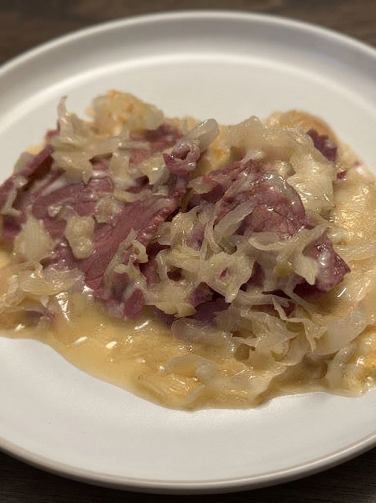 Keto-Friendly Reuben Casserole! There are some recipes that make you hungry just thinking about them. A good Reuben is definitely one of those recipes for me. The combination of tender corned beef, tangy sauerkraut, melty Swiss cheese, creamy dressing, and that unmistakable savory flavor is hard to resist. But sometimes I don't want to make sandwiches, toast bread, or stand around assembling individual Reubens. That's exactly where this Keto-Friendly Reuben Casserole comes in. I made this one on a weekend when I was craving a Reuben but wanted something a little easier and more comforting. Instead of building sandwiches, I layered everything into one casserole dish and let the oven do the work. And honestly? It was even better than I expected. The corned beef gets warm and tender, the sauerkraut adds that delicious tanginess, the Swiss cheese melts into all the layers, and the creamy dressing brings everything together. My family kept going back for "just one more bite," which is usually how I know a recipe is going to become a regular. What I especially love about this casserole is that you get all those classic Reuben flavors without needing traditional rye bread. It's hearty, cheesy, comforting, and incredibly easy to put together. If you love Reubens, this is one of those recipes you absolutely need to have in your dinner rotation. ❤️ Why You'll Love This Keto Reuben Casserole All the classic Reuben flavors in one dish No traditional bread required Creamy, cheesy, and incredibly comforting A great way to use leftover corned beef Easy enough for a weeknight dinner Excellent for meal prep Perfect for St. Patrick's Day or any time you're craving a Reuben Family-friendly and easy to customize Ready with minimal hands-on work And perhaps my favorite part: Everything cooks together in one casserole dish. Less fuss. Less cleanup. More cheesy Reuben goodness. 🛒 Ingredients For the Casserole 1½ pounds cooked corned beef, chopped or shredded 4 cups sauerkraut, thoroughly drained and squeezed dry 8 ounces Swiss cheese, shredded ½ cup shredded mozzarella cheese ½ cup mayonnaise ½ cup sour cream ¼ cup sugar-free Thousand Island or Russian-style dressing 1 tablespoon Dijon mustard 1 teaspoon Worcestershire sauce ½ teaspoon garlic powder ½ teaspoon onion powder ¼ teaspoon black pepper 2 tablespoons chopped fresh parsley, optional Optional Low-Carb Topping ½ cup crushed keto-friendly crackers or pork rinds 1 tablespoon melted butter The topping is completely optional. The casserole is delicious without it, especially if you want to keep things simple. 👩‍🍳 How to Make Keto-Friendly Reuben Casserole Step 1: Preheat the Oven Preheat your oven to 375°F (190°C). Lightly grease a 9×13-inch casserole dish with cooking spray or a little butter. Set it aside while you prepare the ingredients. 🥩 Step 2: Prepare the Corned Beef If you're using leftover corned beef, chop it into small bite-sized pieces or shred it with two forks. You don't want huge chunks because you want a little corned beef in nearly every bite. If you're using deli corned beef, you can simply chop it into strips or small pieces. I actually love using leftover corned beef after a big family dinner because it gives the meat a second life. 🥬 Step 3: Drain the Sauerkraut This is an important step. Place the sauerkraut in a colander and drain it really well. Then use clean hands, paper towels, or a kitchen towel to squeeze out as much excess liquid as possible. Don't skip this. Too much liquid can make your casserole watery instead of creamy and cheesy. I learned this one the hard way. The first time I made a sauerkraut casserole, I thought draining it was enough. It wasn't. Now I squeeze it thoroughly every time. 🥣 Step 4: Make the Creamy Reuben Sauce In a medium bowl, combine: Mayonnaise Sour cream Thousand Island or Russian-style dressing Dijon mustard Worcestershire sauce Garlic powder Onion powder Black pepper Stir until smooth and creamy. Give it a taste. If you like a stronger Reuben flavor, add another teaspoon of Dijon. If you prefer it creamier and milder, add another spoonful of sour cream. This sauce is what ties all those flavors together. 🧀 Step 5: Build the Casserole Spread about half of the sauerkraut across the bottom of the prepared casserole dish. Add half of the corned beef. Drizzle or spoon half of the creamy sauce over the top. Sprinkle with half of the Swiss cheese. Repeat the layers with the remaining sauerkraut, corned beef, sauce, and cheese. Finish with the remaining mozzarella. Don't worry about making the layers perfect. This is a cozy casserole. It doesn't need to look fancy going into the oven. 🥨 Step 6: Add the Optional Crunchy Topping If you're using a low-carb crunchy topping, combine the crushed keto crackers or pork rinds with melted butter. Sprinkle the mixture evenly over the casserole. You can also skip the topping completely and let the melted Swiss and mozzarella create the golden cheesy crust. Both versions are delicious. 🔥 Step 7: Bake Cover the casserole loosely with aluminum foil. Bake for approximately 20 minutes. Remove the foil and continue baking for another 10–15 minutes, or until the cheese is completely melted and bubbling around the edges. If you want a deeper golden top, turn on the broiler for the final 1–2 minutes. Keep a close eye on it because cheese can go from beautifully browned to burnt surprisingly quickly. ⏰ Step 8: Let It Rest Remove the casserole from the oven and let it rest for about 5–10 minutes before serving. This gives the creamy filling a chance to settle. It also makes the casserole much easier to scoop. And honestly, those few minutes are torture because your kitchen will smell absolutely incredible. 🥄 The Best Way to Serve It Scoop generous portions onto plates while the casserole is still warm. Add a little extra Thousand Island dressing over the top if you'd like. A sprinkle of fresh parsley makes it look beautiful, too. And if you really want the full Reuben experience, serve it alongside crunchy pickles. The cool, crisp pickle against the warm, creamy casserole is fantastic. ✨ Tips for the Best Reuben Casserole Squeeze the sauerkraut dry This is probably the most important tip. Sauerkraut contains a lot of liquid. Removing as much as possible keeps the casserole rich and creamy. Don't use too much dressing It can be tempting to add extra sauce, but too much can make the casserole overly wet. You can always serve additional dressing on the side. Use good Swiss cheese Swiss cheese gives the casserole that classic Reuben flavor. For the best melting texture, shred it yourself if possible. Chop the corned beef fairly small Smaller pieces distribute throughout the casserole so every serving gets plenty. Let it rest Don't immediately scoop it out of the oven. A few minutes of resting makes a big difference. Watch the salt Corned beef, sauerkraut, and Swiss cheese can all be salty. Taste the sauce before adding any additional salt. In many cases, you won't need any. 🥩 What Kind of Corned Beef Should You Use? You have several options. Leftover Homemade Corned Beef This is my favorite. It's tender, flavorful, and perfect for turning leftovers into a completely different meal. Deli Corned Beef A convenient option when you don't have leftover corned beef. Ask for thick slices so you can chop them into bite-sized pieces. Canned Corned Beef It can work in a pinch, although the texture will be different from freshly cooked or deli corned beef. For the best casserole, I prefer homemade or deli corned beef. 🧀 Cheese Options Swiss is the classic choice, but you can experiment. Try: Gruyère Provolone Mozzarella Monterey Jack White cheddar Havarti For the most traditional Reuben flavor, though, Swiss cheese is hard to beat. 🥒 Easy Variations Bacon Reuben Casserole Add 4–6 slices of cooked, crumbled bacon before layering. Because bacon makes almost everything better. Spicy Reuben Casserole Add a little hot sauce or crushed red pepper flakes to the creamy sauce. Pickle Reuben Casserole Add finely chopped dill pickles to the sauce for an extra tangy bite. Extra Cheesy Reuben Add another handful of shredded Swiss or mozzarella over the top before baking. Creamy Mushroom Reuben Sauté sliced mushrooms and layer them into the casserole with the corned beef. Turkey Reuben Casserole Replace the corned beef with sliced turkey for a lighter variation inspired by a Rachel sandwich. 🥗 What to Serve With Reuben Casserole Because this casserole is rich and hearty, I like serving it with something fresh and crunchy. Try: Dill pickles Cucumber salad Green salad Roasted broccoli Steamed green beans Roasted cauliflower Coleslaw Pickled vegetables Sautéed cabbage A simple green salad with a light vinaigrette is one of my favorites. The acidity helps balance all that creamy cheese. 🥒 Don't Forget the Pickles If you're a Reuben fan, you already know. Pickles belong on the plate. I like serving a generous pile of crisp dill pickles alongside the casserole. You can also chop a few pickles and stir them directly into the sauce. That little bit of acidity cuts through the richness and gives the casserole an extra punch of flavor. 🍽️ Can You Make This Ahead? Absolutely. This casserole is a great make-ahead dinner. Assemble everything in the casserole dish, cover tightly, and refrigerate until you're ready to bake. If the casserole is going straight from the refrigerator into the oven, you may need to add a few extra minutes to the cooking time. Don't leave it sitting at room temperature for an extended period before baking. 🧊 Storage Allow leftover casserole to cool and refrigerate it in an airtight container. For best quality, enjoy refrigerated leftovers within 3–4 days. You can reheat individual portions in the microwave, but the oven or air fryer will give you a better texture. 🔥 How to Reheat Reuben Casserole Oven Place the casserole in an oven-safe dish and cover loosely with foil. Reheat at 350°F (175°C) until warmed through. Remove the foil during the final few minutes if you want the cheese to become bubbly again. Air Fryer Place an individual portion in an air-fryer-safe dish and heat at around 350°F (175°C) until hot. Keep an eye on the cheese. Microwave For the fastest option, microwave individual portions in short intervals until heated through. The microwave won't recreate the crispy top, but it works perfectly well for lunch. ❄️ Can You Freeze Reuben Casserole? Yes, although the texture of the sauerkraut and creamy sauce may change slightly after freezing and thawing. For best results, freeze portions in airtight freezer-safe containers. Thaw overnight in the refrigerator before reheating. Reheat gently in the oven until hot. If you know you'll be freezing the casserole, I recommend leaving off any crunchy topping until you're ready to reheat and serve. 🥑 How to Keep It Keto-Friendly The main things to watch are the dressing and any crunchy topping. Choose: Sugar-free or low-carb Thousand Island dressing Unsweetened sour cream Full-fat cheese Corned beef without added sugary glazes Sauerkraut without added sugar Pork rinds or a keto-friendly cracker alternative instead of traditional breadcrumbs Always check the labels on prepared dressings and deli meats because carbohydrate counts can vary considerably between brands. ❓ Frequently Asked Questions Is Reuben casserole keto-friendly? It can be. This version skips traditional rye bread and uses low-carb ingredients such as corned beef, sauerkraut, cheese, and a creamy dressing. Check the labels on your dressing and corned beef if you're following a strict ketogenic diet. Does Reuben casserole contain bread? Traditional Reuben sandwiches contain rye bread, but this casserole doesn't need it. The corned beef, sauerkraut, Swiss cheese, and creamy dressing provide all the classic flavors without the bread. Can I use leftover corned beef? Absolutely. This is one of the best ways to use leftover corned beef after a holiday meal. Can I use deli corned beef? Yes. Thick-cut deli corned beef works very well. Why is my casserole watery? The most common reason is excess moisture from the sauerkraut. Drain it thoroughly and squeeze out as much liquid as possible before adding it to the casserole. Can I use Russian dressing instead of Thousand Island? Yes. Both work beautifully. Russian dressing tends to have a slightly different flavor, but it's an excellent choice for a Reuben-inspired casserole. Can I make this without mayonnaise? Yes. Increase the sour cream or use a combination of Greek yogurt and sour cream. Keep in mind that the flavor and texture will change slightly. Can I use another cheese? Absolutely. Gruyère, provolone, mozzarella, Havarti, or white cheddar are all good alternatives. Can I add rye flavor without rye bread? If you want to mimic the flavor of rye, a tiny amount of caraway seed can be added to the casserole or sauce. Use it sparingly because its flavor is strong. Can I make this in a smaller casserole dish? Yes. If you're making a half batch, an 8×8-inch or similar baking dish works well. The casserole may be deeper, so adjust the baking time as needed. How do I make the top extra crispy? Add a small amount of crushed pork rinds mixed with melted butter before baking, or broil the casserole for the final minute or two. Can I make this in a slow cooker? You can, although I prefer the oven because it gives you a better melted and browned cheese topping. If using a slow cooker, keep the cooking time gentle and avoid adding too much liquid. 📝 Recipe at a Glance Recipe: Keto-Friendly Reuben Casserole Prep Time: 15 minutes Cook Time: 30–35 minutes Resting Time: 5–10 minutes Total Time: About 50 minutes Servings: 6 Course: Dinner / Casserole Cuisine: American-Inspired Ingredients 1½ pounds cooked corned beef 4 cups sauerkraut, drained and squeezed dry 8 ounces Swiss cheese, shredded ½ cup mozzarella ½ cup mayonnaise ½ cup sour cream ¼ cup sugar-free Thousand Island or Russian dressing 1 tablespoon Dijon mustard 1 teaspoon Worcestershire sauce ½ teaspoon garlic powder ½ teaspoon onion powder ¼ teaspoon black pepper 2 tablespoons parsley, optional Optional topping: ½ cup crushed keto-friendly crackers or pork rinds 1 tablespoon melted butter 👩‍🍳 Quick Instructions Preheat oven to 375°F (190°C). Grease a 9×13-inch casserole dish. Chop or shred the cooked corned beef. Drain and thoroughly squeeze the sauerkraut dry. Mix mayonnaise, sour cream, dressing, Dijon, Worcestershire sauce, garlic powder, onion powder, and pepper. Layer half the sauerkraut in the casserole dish. Add half the corned beef. Add half the creamy sauce. Sprinkle with half the Swiss cheese. Repeat the layers. Finish with mozzarella and the optional crunchy topping. Cover and bake for 20 minutes. Uncover and bake another 10–15 minutes, until hot and bubbling. Broil for 1–2 minutes if you want a golden top. Rest for 5–10 minutes before serving. Serve with pickles and extra dressing if desired. ❤️ The Reuben Craving Is Officially Solved Some nights call for a sandwich. Other nights call for a casserole dish. This recipe is definitely for the second kind of night. I love how comforting it feels to pull this bubbling casserole from the oven and see that golden layer of melted cheese on top. Then you scoop into it and get corned beef, tangy sauerkraut, creamy dressing, and cheese all in one bite. It's messy in the best possible way. And there's something especially satisfying about taking flavors from a classic favorite and turning them into a dinner that's easier to make and easier to share. This is the kind of meal I would happily make on a chilly evening, for a casual family dinner, or whenever that unmistakable Reuben craving hits. Serve it with crisp pickles, a simple salad, and maybe a little extra dressing on the side. Then sit down and enjoy it. Because sometimes you don't need to reinvent dinner. You just need to put all your favorite flavors into one dish, cover it with cheese, and let the oven work its magic. Classic Reuben flavor. Cozy casserole comfort. No rye bread required.