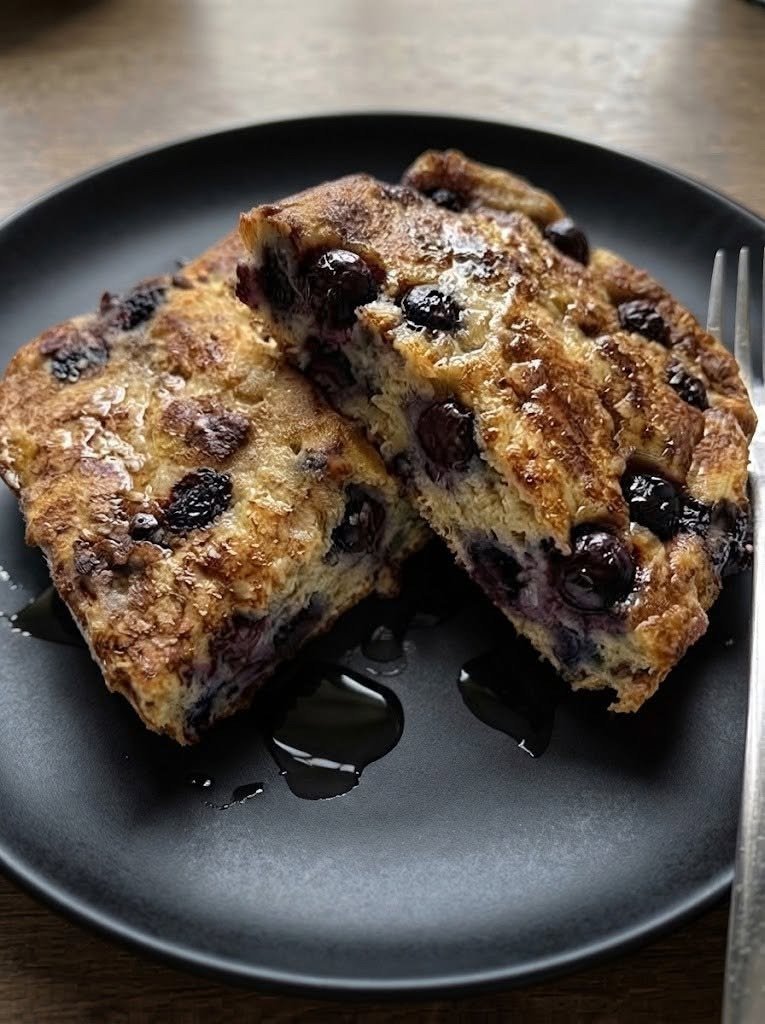 🫐 Keto Blueberry French Toast Casserole There are some breakfasts that make you want to stay at the table a little longer, and this Keto Blueberry French Toast Casserole is definitely one of them. I love recipes like this on slow weekend mornings when everyone is home and nobody is in a rush. Instead of standing over a skillet flipping individual pieces of French toast, you assemble everything in one baking dish, let the oven do the work, and end up with a warm, golden casserole filled with creamy custard, juicy blueberries, and little pockets of buttery goodness. The first time I made a low-carb version, I wasn't sure how it would compare with the classic French toast casserole I remembered. But after adding vanilla, cinnamon, blueberries, and a crunchy pecan topping, I realized I didn't miss the extra sugar at all. My favorite part is the contrast between the crisp golden edges and the soft, custardy center. And when you spoon a little warm berry goodness over the top, it feels like a special brunch rather than a "keto" breakfast. ❤️ Why You'll Love This Keto French Toast Casserole Easy one-dish breakfast Perfect for weekends and holidays Can be assembled ahead of time Sweet, creamy, and comforting Packed with juicy blueberries Naturally low-carb when made with keto bread No standing over the stove flipping French toast Great for feeding a crowd Delicious warm or reheated 🛒 Ingredients You'll Need For the Casserole 8 slices keto-friendly bread, cut into 1-inch cubes 1 cup fresh blueberries 6 large eggs 1 1/2 cups unsweetened almond milk 1/2 cup heavy cream 1/4 cup powdered allulose or monk fruit sweetener 1 teaspoon vanilla extract 1 teaspoon ground cinnamon 1/4 teaspoon nutmeg 1/4 teaspoon salt 2 tablespoons melted butter For the Pecan Topping 1/3 cup chopped pecans 2 tablespoons almond flour 2 tablespoons powdered allulose 2 tablespoons cold butter 1/2 teaspoon cinnamon Optional Toppings Extra fresh blueberries Sugar-free maple syrup Powdered keto sweetener Whipped cream Chopped pecans Lemon zest Tip: Keto breads vary considerably in their carbohydrate and fiber content, so check the label on the bread you choose if you're tracking net carbs closely. 🍞 How to Make Keto Blueberry French Toast Casserole 1. Prepare the Baking Dish Preheat your oven to 350°F (175°C). Lightly butter a 9 × 13-inch baking dish. You can also use a little nonstick spray if preferred. 2. Cube the Bread Cut the keto bread into roughly 1-inch cubes. If your bread is very soft and fresh, spread the cubes on a baking sheet and let them sit uncovered for 30–60 minutes. You can also lightly toast them in a 300°F oven for about 10 minutes. Slightly dried bread absorbs the custard much better and gives the finished casserole a more French-toast-like texture. 3. Layer the Bread and Blueberries Place about half of the bread cubes into the prepared baking dish. Scatter half of the blueberries over the bread. Add the remaining bread cubes, followed by the remaining blueberries. Try to distribute the berries fairly evenly so you get blueberries throughout the casserole rather than only on top. 🥚 Make the Custard 4. Whisk Everything Together In a large bowl, whisk together: Eggs Almond milk Heavy cream Powdered sweetener Vanilla Cinnamon Nutmeg Salt Melted butter Whisk until smooth and completely combined. The vanilla and cinnamon are especially important here. They give the casserole that unmistakable warm French-toast flavor. 5. Pour Over the Bread Slowly pour the custard evenly over the bread and blueberries. Use the back of a spoon or your hands to gently press the bread down into the custard. You want most of the bread to become coated and moistened. Let the casserole sit for 10–15 minutes before baking. If you're preparing it the night before, cover it tightly and refrigerate overnight instead. 🌰 Make the Crunchy Pecan Topping 6. Mix the Topping In a small bowl, combine: Chopped pecans Almond flour Powdered sweetener Cinnamon Add the cold butter. Use your fingertips or a fork to work the butter into the mixture until you have coarse crumbs. Scatter the topping evenly over the casserole. This little crunchy layer is one of my favorite parts. The pecans toast in the oven while the casserole puffs and turns golden underneath. 🔥 Bake the Casserole 7. Bake Until Golden Place the casserole in the preheated oven. Bake uncovered for 40–50 minutes. The center should be set but still slightly soft and custardy. The edges should look golden and puffed. If the top starts browning too quickly, loosely cover the casserole with foil during the final 10–15 minutes. Let it cool for 10 minutes before slicing. This gives the custard time to settle so the pieces hold together better. 🫐 Make It Extra Blueberry-Delicious If you really love blueberries, make a quick warm blueberry topping while the casserole rests. Add: 1/2 cup blueberries 1 tablespoon water 1 tablespoon powdered allulose 1 teaspoon lemon juice to a small saucepan. Cook over medium-low heat for 3–5 minutes, gently crushing some of the berries with a spoon. You don't want a thick jam—just a warm, spoonable blueberry sauce. Pour it over individual servings. The warm berries against the creamy French toast are incredible. ✨ My Best Tips for Perfect Keto French Toast Casserole Use slightly stale bread This is probably the most important tip. Fresh, soft keto bread can become mushy when soaked in custard. Slightly dried bread absorbs the mixture while still holding its shape. Don't skip the resting time Even 10–15 minutes allows the bread to absorb more of the custard. Don't overbake You want the center just set. Overbaking can make the casserole dry and rubbery. Use full-fat dairy Heavy cream adds richness and helps make the casserole taste more like traditional French toast. Don't overload it with blueberries Blueberries release moisture as they bake. A generous but balanced amount gives you blueberry flavor without making the casserole watery. Let it rest before serving Those extra 10 minutes make a surprisingly big difference in texture. 🌙 Can You Make It the Night Before? Yes—and this is one of the best things about this recipe. Assemble the casserole completely, including the custard, then cover it tightly and refrigerate overnight. For the best crunchy topping, I recommend preparing the pecan mixture separately and sprinkling it over the casserole right before baking. In the morning: Remove the casserole from the refrigerator. Let it sit at room temperature for about 20–30 minutes. Add the pecan topping. Bake at 350°F for about 45–55 minutes, or until the center is set. If the casserole is still very cold when it goes into the oven, it may need a few additional minutes. 🍋 Easy Variations Lemon Blueberry French Toast Casserole Add 1 tablespoon finely grated lemon zest to the custard. Blueberry and lemon are a beautiful combination. Blueberry Cheesecake Version Drop small spoonfuls of softened cream cheese between the bread cubes before adding the custard. You can also add a little lemon zest. It's incredibly rich and dessert-like. Cinnamon Pecan Version Add another 1/2 teaspoon cinnamon to the custard and increase the pecans on top. Perfect for a chilly morning. Raspberry Blueberry Casserole Use half blueberries and half raspberries. The raspberries add a lovely tart flavor. Chocolate Blueberry Version Add a small handful of sugar-free dark chocolate chips along with the blueberries. This one is especially good if you're making it for dessert. Coconut Almond Version Replace the pecans with sliced almonds and add 2 tablespoons unsweetened shredded coconut. 🥞 What Bread Works Best? Choose a sturdy keto bread rather than an extremely soft sandwich bread. Good options include: Keto white bread Keto wheat bread Low-carb brioche-style bread Homemade almond-flour bread Homemade coconut-flour bread A slightly firm bread gives you a much better custardy center. If you have bread that's already a day or two old, that's actually perfect. 🍁 What Can You Put on Top? This is where everyone can make their own serving. Try: Sugar-free maple syrup Fresh blueberries Warm blueberry sauce Whipped cream Chopped pecans Cinnamon Powdered monk fruit sweetener A little almond butter Lemon zest My personal favorite is warm blueberries, a few toasted pecans, and a very light drizzle of sugar-free maple syrup. ☕ What to Serve With It Although this casserole is satisfying on its own, it's wonderful as part of a larger brunch. Serve it with: Scrambled eggs Bacon Breakfast sausage Turkey sausage Fresh berries Greek yogurt Coffee Tea Sugar-free hot chocolate For a holiday brunch, I like serving smaller squares alongside eggs and crispy bacon. The salty bacon with the sweet blueberry casserole is such a good combination. 🥓 Make It a Complete Keto Breakfast If you're serving this to a hungry family, don't worry about making the casserole enormous. Instead, pair a moderate serving with a protein-rich side. A few slices of bacon or sausage make this feel like a complete breakfast without requiring another complicated recipe. And if you're hosting brunch, this makes a beautiful centerpiece surrounded by savory breakfast dishes. 🧊 Storage Let leftovers cool completely. Cover the baking dish or transfer individual servings to airtight containers. Refrigerate for up to 4 days. To reheat: Microwave individual servings for about 45–90 seconds, or Warm in a 325°F oven until heated through. The oven gives you the best texture because it helps the top crisp back up. ❄️ Can You Freeze It? Yes. Cut the cooled casserole into individual portions. Wrap each piece tightly, then place the portions in a freezer-safe container or bag. Freeze for up to 2 months for the best quality. Thaw overnight in the refrigerator. Reheat in a 325°F oven until warm. You can add fresh blueberries and pecans after reheating to brighten everything back up. ❓ Frequently Asked Questions Is French toast casserole keto? Traditional French toast casserole is usually made with regular bread and significant amounts of sugar or syrup. This version uses keto-friendly bread and a low-carb sweetener instead. Can I use frozen blueberries? Yes. There's no need to thaw them first. Add them directly to the casserole, although you may need a few extra minutes of baking time. Why is my casserole soggy? The most common causes are very soft bread, too much custard, or underbaking. Using slightly dried bread and allowing the casserole to rest before baking helps. Can I use heavy cream instead of almond milk? You can, although the casserole will be richer and heavier. I prefer the combination of almond milk and heavy cream. Can I use coconut milk? Yes. Use unsweetened coconut milk. Keep in mind that it may add a subtle coconut flavor. What sweetener works best? Powdered allulose works particularly well because it dissolves smoothly and doesn't leave much texture behind. Powdered monk fruit or another keto-friendly sweetener can also work. Can I leave out the pecan topping? Absolutely. The casserole is delicious without it, but the pecans add a wonderful crunch. Can I add cream cheese? Definitely. Small pieces of softened cream cheese tucked between the bread cubes create a cheesecake-like variation. How do I know when it's done? The edges should be golden and puffed, while the center should look set but still have a slight softness when gently shaken. 📝 Recipe at a Glance Prep Time: 15 minutes Resting Time: 10–15 minutes Cook Time: 40–50 minutes Total Time: About 1 hour 10 minutes Servings: 8 Category: Breakfast / Brunch Cuisine: American Method: Baked 🫐 Keto Blueberry French Toast Casserole Recipe Ingredients Casserole 8 slices keto-friendly bread, cubed 1 cup fresh blueberries 6 large eggs 1 1/2 cups unsweetened almond milk 1/2 cup heavy cream 1/4 cup powdered allulose or monk fruit sweetener 1 tsp vanilla extract 1 tsp cinnamon 1/4 tsp nutmeg 1/4 tsp salt 2 tbsp melted butter Pecan Topping 1/3 cup chopped pecans 2 tbsp almond flour 2 tbsp powdered allulose 2 tbsp cold butter 1/2 tsp cinnamon Optional Fresh blueberries Sugar-free maple syrup Whipped cream Lemon zest Instructions Preheat oven to 350°F (175°C) and butter a 9 × 13-inch baking dish. Cut keto bread into 1-inch cubes. If very fresh, let it dry slightly or toast for about 10 minutes at 300°F. Arrange half the bread in the baking dish. Scatter half the blueberries over the bread. Add the remaining bread and blueberries. Whisk eggs, almond milk, heavy cream, sweetener, vanilla, cinnamon, nutmeg, salt, and melted butter. Pour the custard evenly over the bread. Gently press the bread into the custard. Rest for 10–15 minutes, or cover and refrigerate overnight. Combine pecans, almond flour, sweetener, and cinnamon. Cut in the cold butter until crumbly. Sprinkle the topping over the casserole. Bake uncovered for 40–50 minutes, until golden and set. Let rest for 10 minutes. Serve warm with your favorite keto-friendly toppings. ❤️ Final Thoughts This Keto Blueberry French Toast Casserole is the kind of breakfast that makes an ordinary morning feel like a little celebration. It's warm and comforting, but the blueberries keep it fresh. The custard makes every bite soft and rich, while those toasted pecans add just enough crunch. And I especially love that it can be prepared the night before. There's something wonderful about waking up on a weekend, putting a prepared casserole into the oven, making a cup of coffee, and letting the kitchen slowly fill with the smell of cinnamon and blueberries. No flipping. No complicated breakfast assembly. Just a beautiful casserole coming out of the oven ready for everyone to gather around. Sometimes the simplest mornings are the ones we remember most.